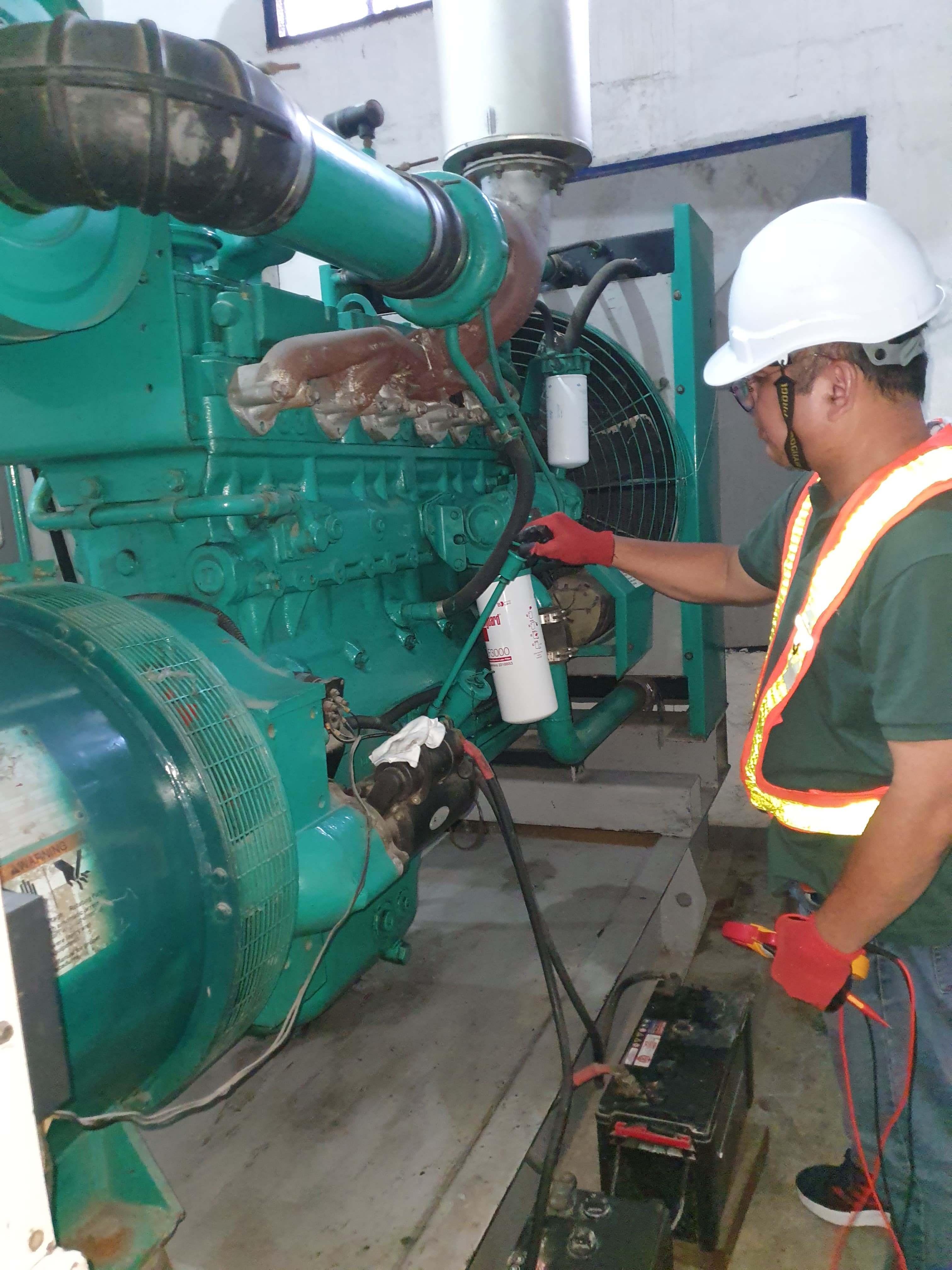 Technician performing PM on generator set and ATS panel