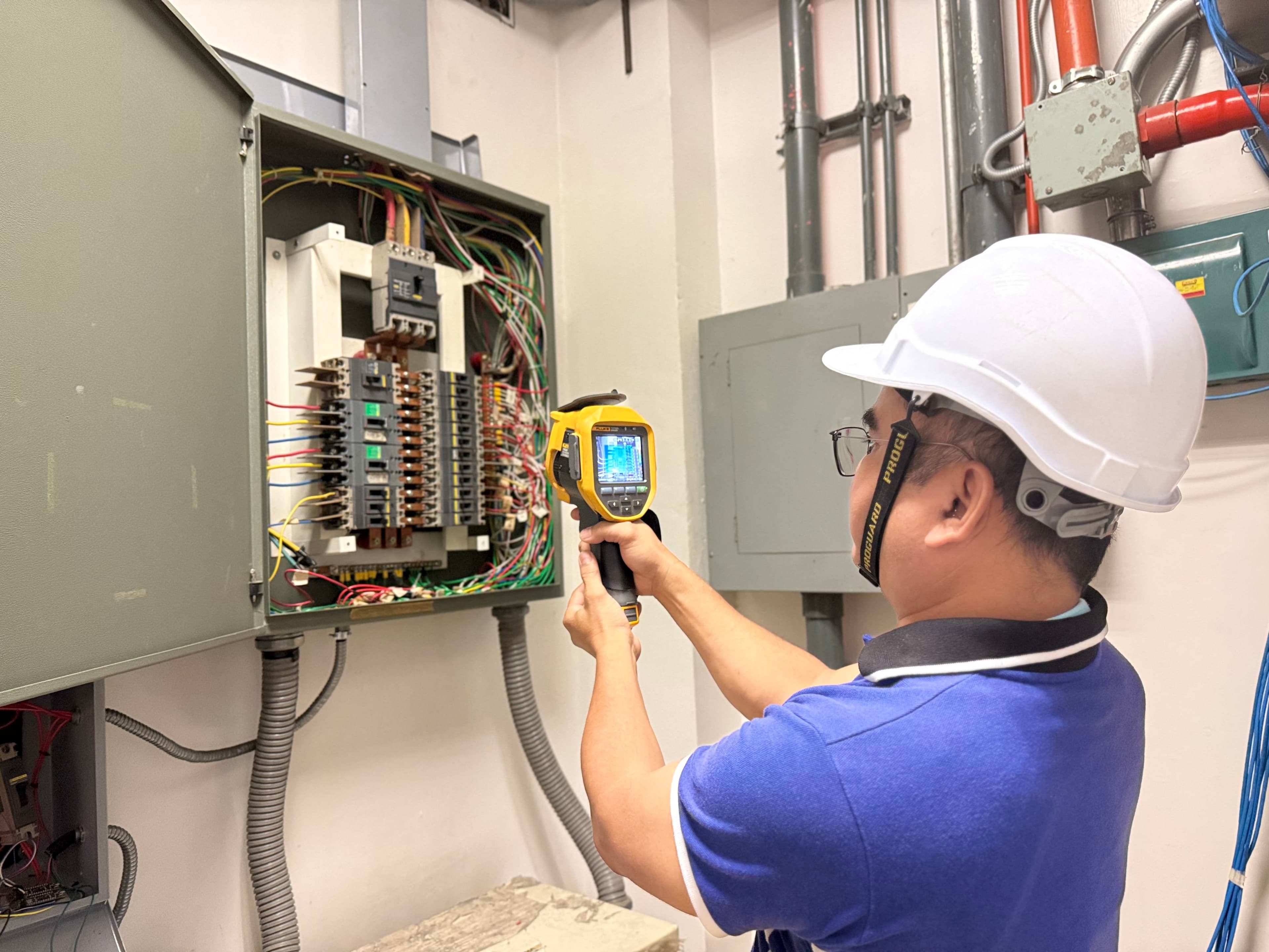 Technician performing thermal scan on distribution panel
